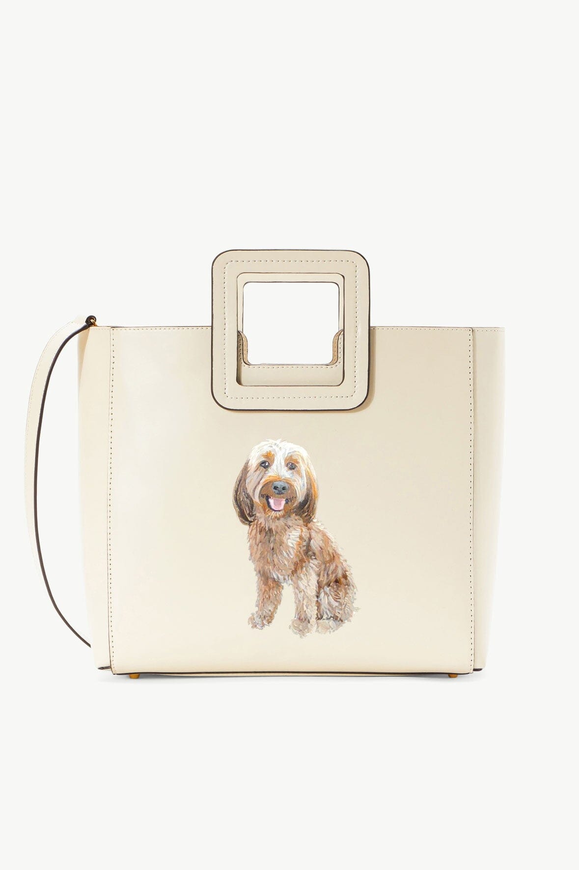 Cream leather tote bag with top handle, pet portrait patch, and square strap frame.