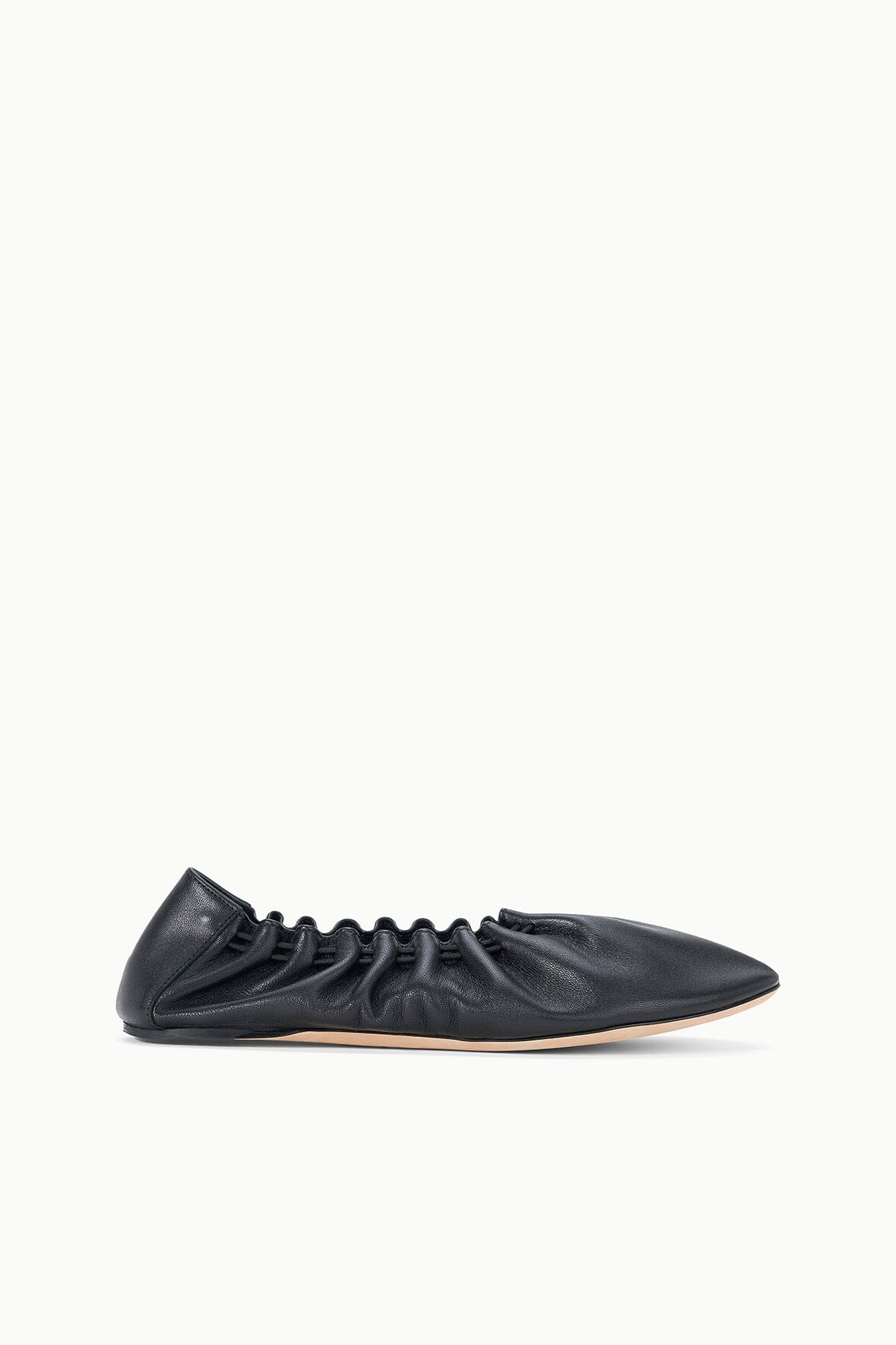 Black flat sneaker shoe, ruched upper with lace-up eyelets, side view