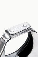 Silver top handle bar with snap button closure detail, black interior