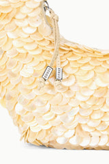 Cream scallop sequined shoulder bag with top handle and zipper pull, side view.