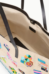 Interior view of large tote with beige lining, black pocket, and colorful beach print exterior