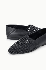 Black woven flat loafer close-up with textured lattice upper
