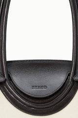 Maude shoulder bag close-up of espresso leather handle strap with embossed brand