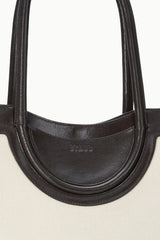 MAUDE tote bag top view with dark leather trim and arched handle loops
