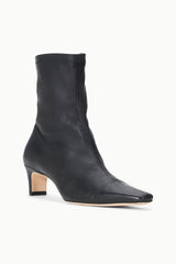 Black ankle sock boot with sleek leather finish and square-toe block heel.