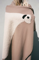 Back view of sheep throw blanket draped in truffle taupe with cream sheep motif