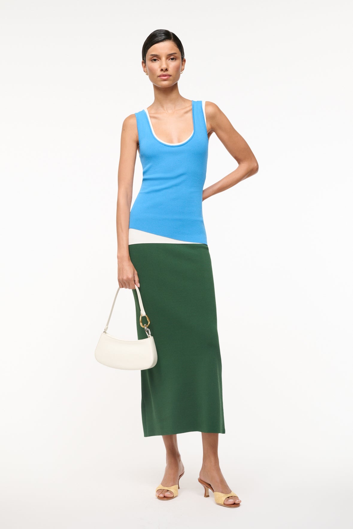 Off-white hobo handbag held by short strap; gold ring hardware and zip top.