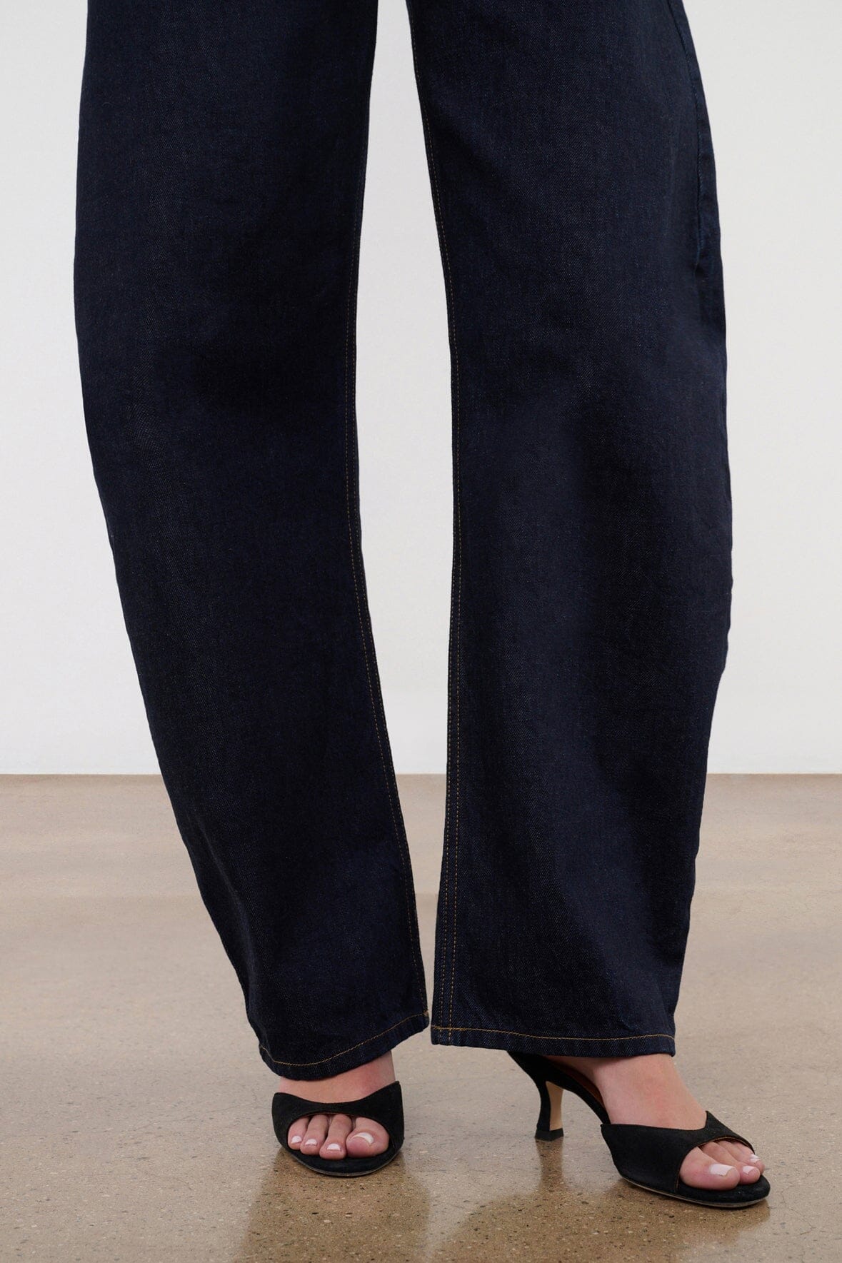 Indigo barrel-leg jeans hem with wide cuff and black sandals