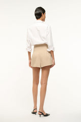 Women’s stone-tan shorts in back view with pleats and cuffed hem