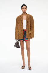 Tan suede jacket with notched lapels, model full-body standing
