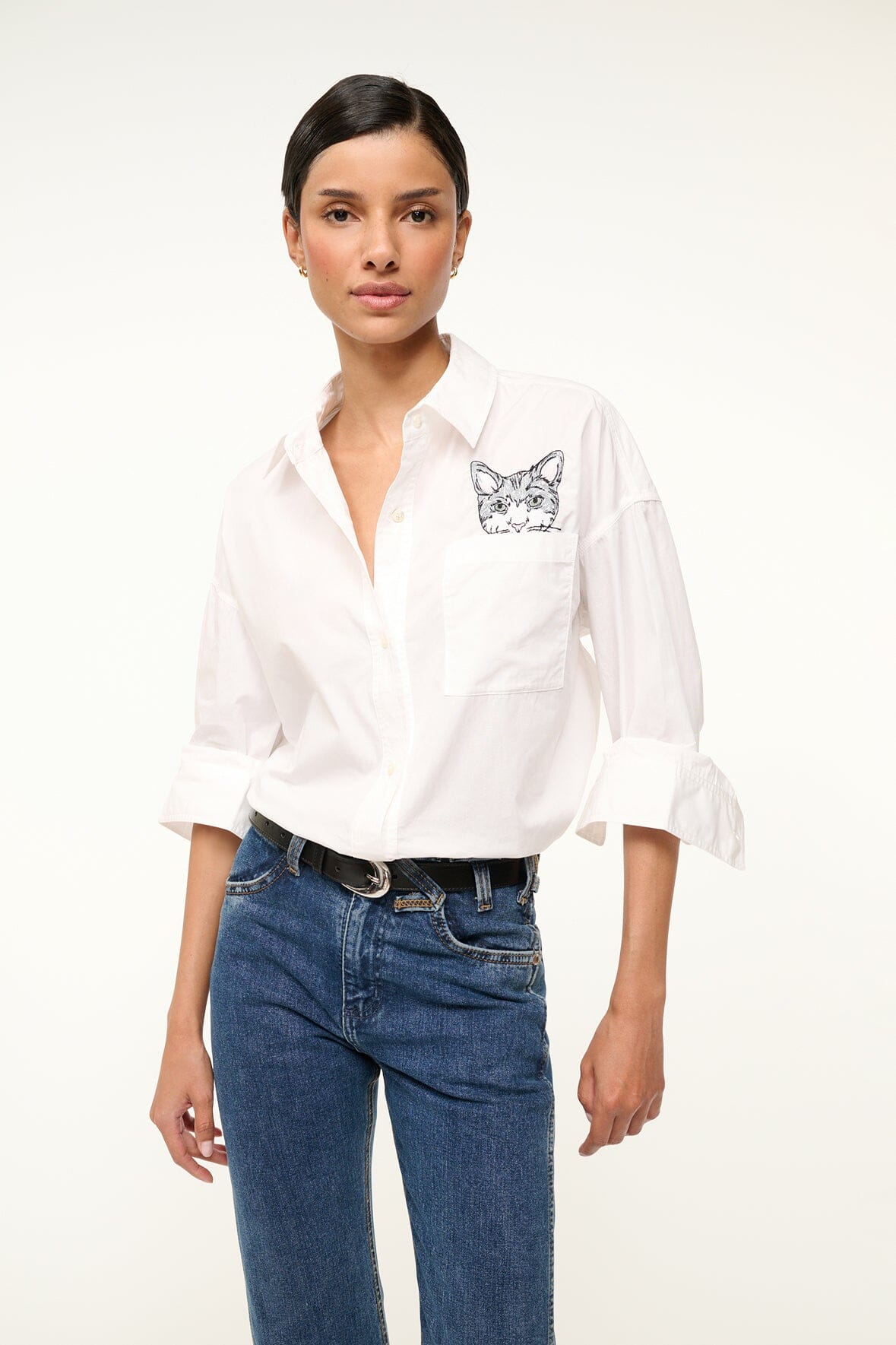 White oversized button-up shirt with cat graphic chest pocket and rolled cuffs