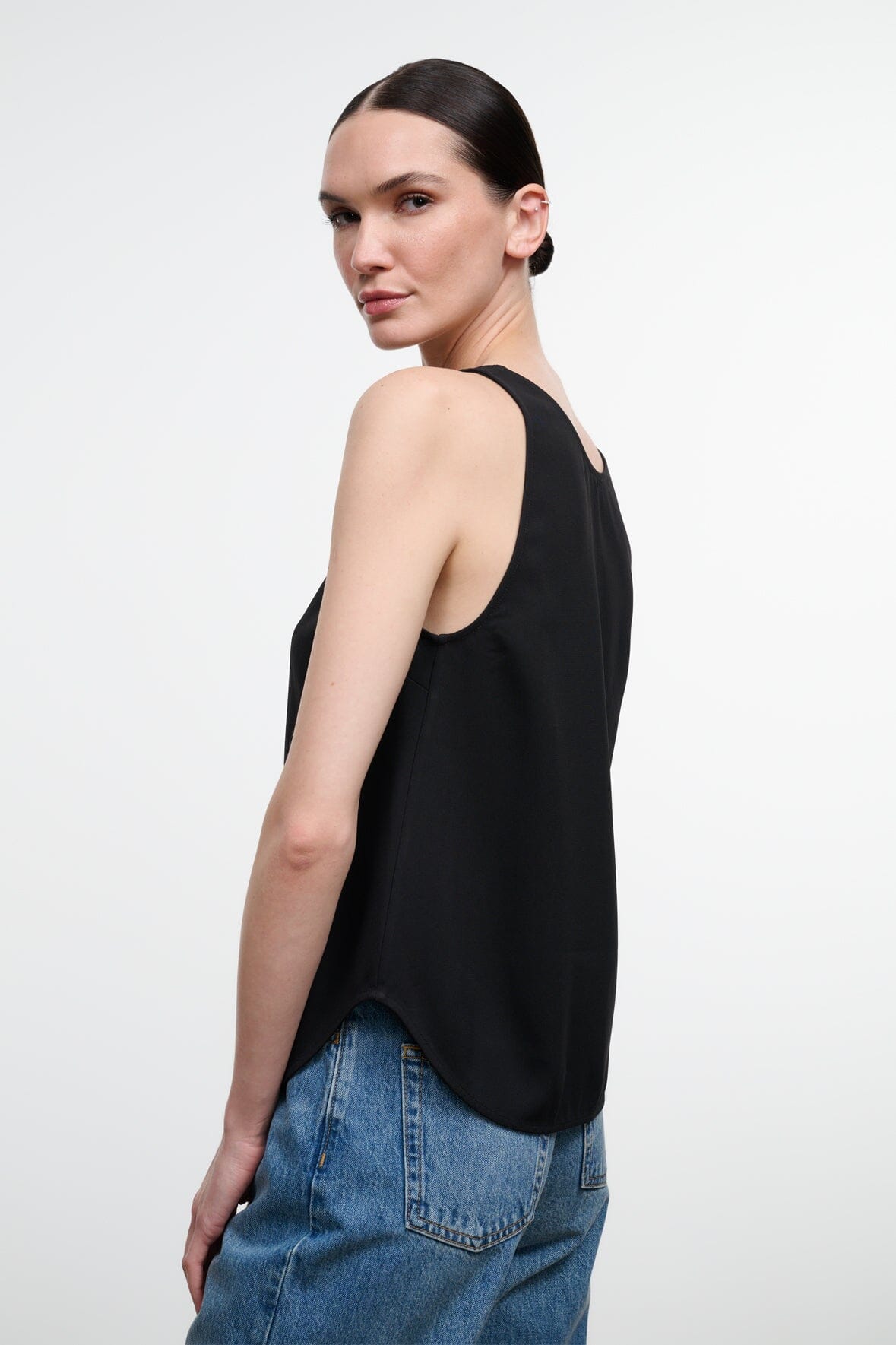 Black sleeveless tank top with scoop neckline, draped hem