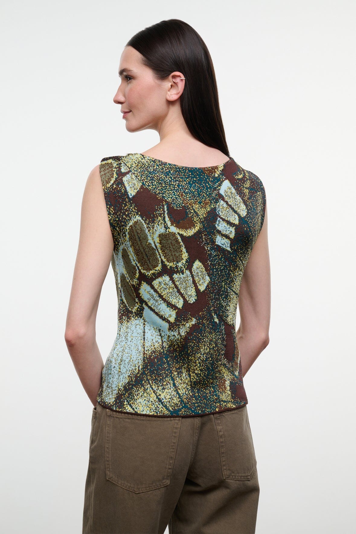 Back view of sleeveless printed top with green, gold, and brown butterfly pattern