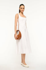 Mini moon bag tan leather carried at side with round top handle.