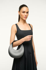 Black mini moon bag held at side with curved top and strap