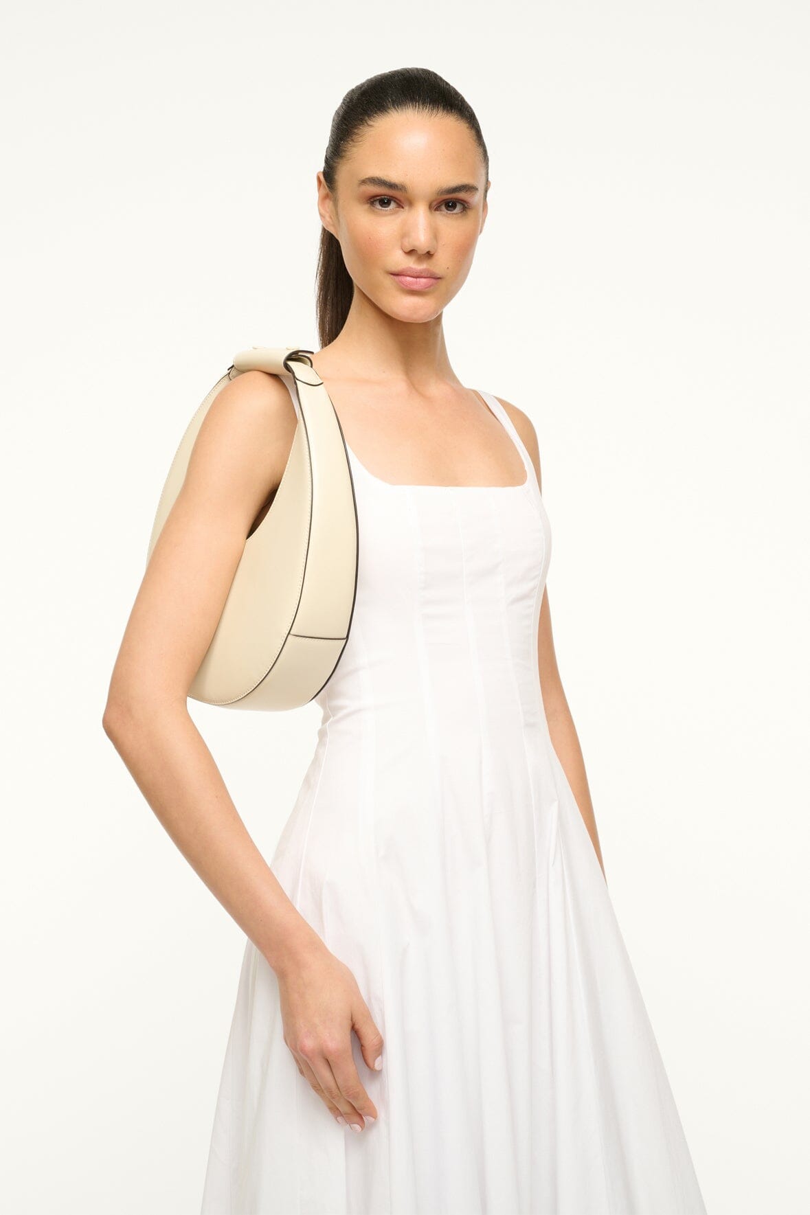Cream crescent moon bag over the shoulder with rounded silhouette