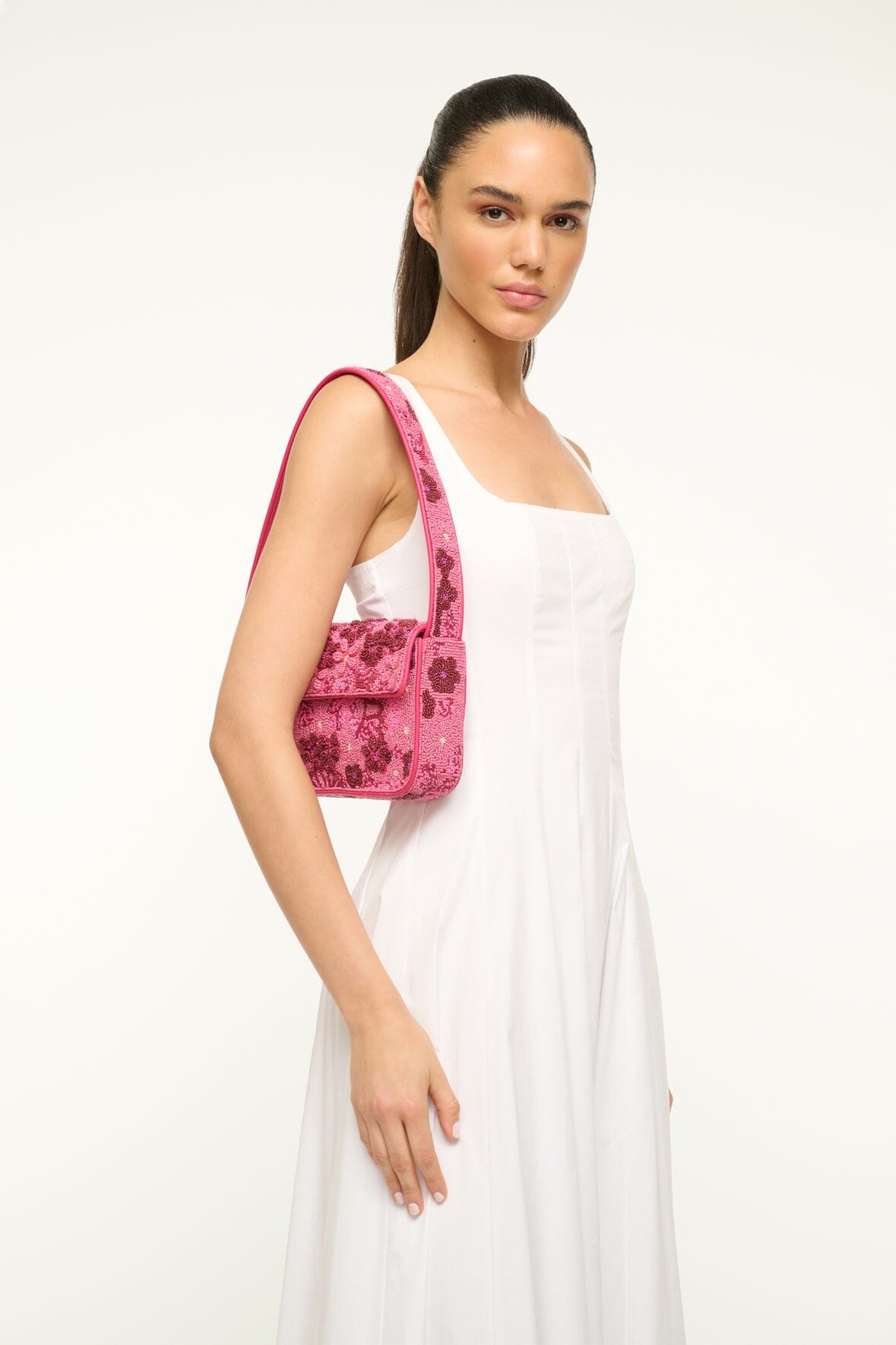Pink beaded handbag with short handle and detailed floral beading pattern.