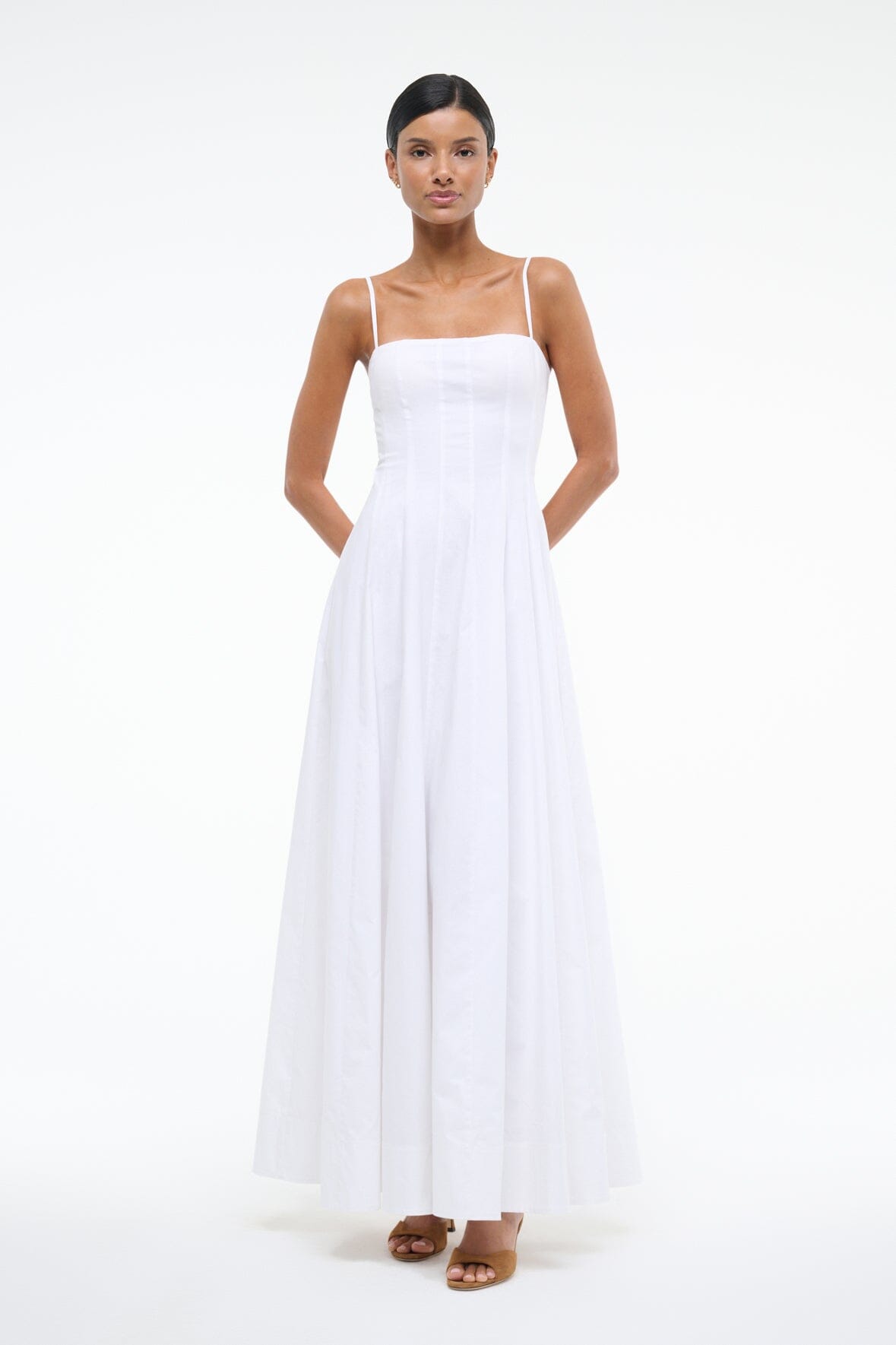 White maxi dress with square neckline and spaghetti straps, fitted bodice and flared skirt