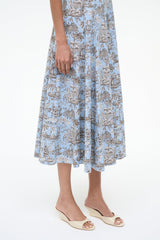 Cream wedge slide sandals worn with a blue patterned dress