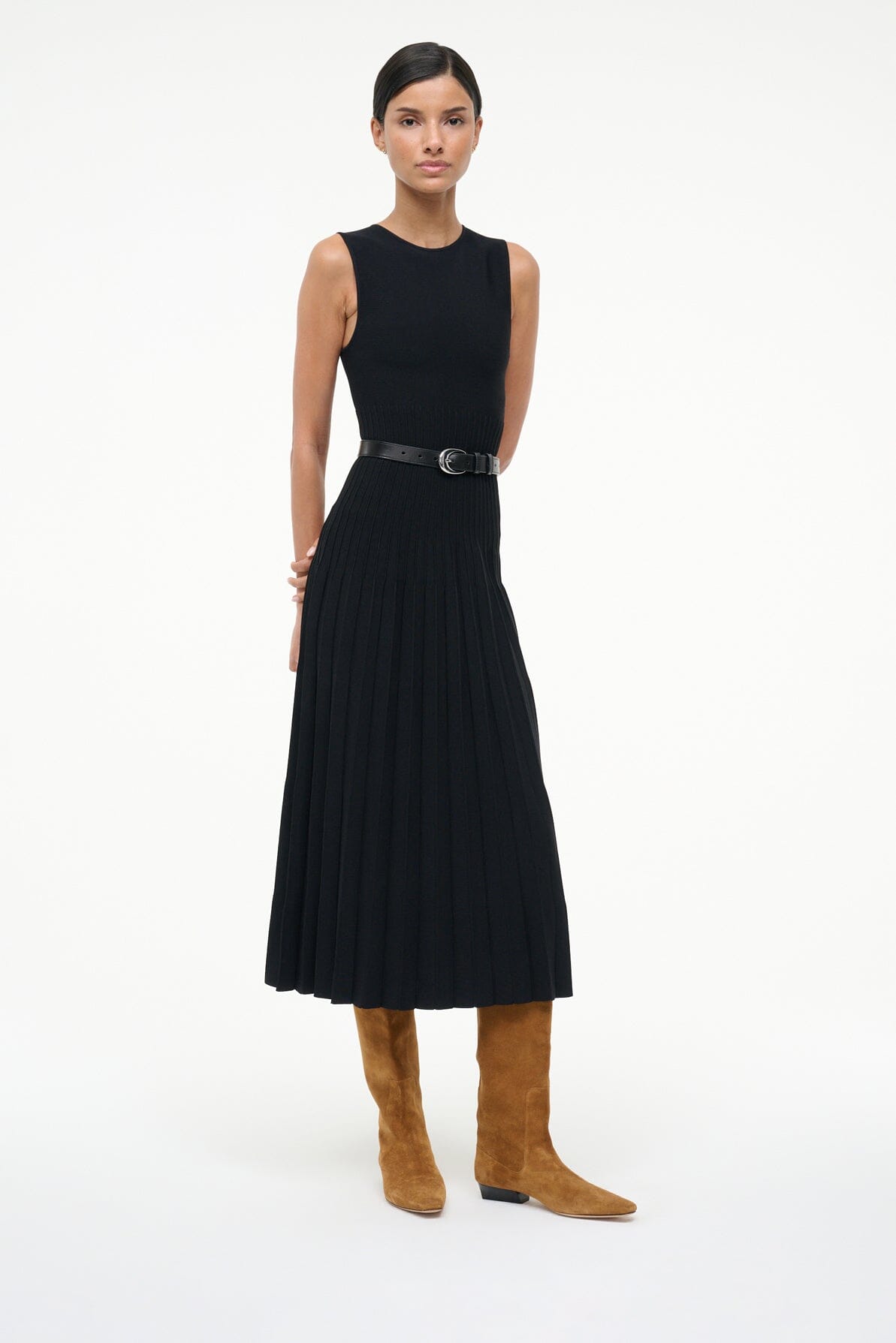 Tan suede flat knee-high boots on model with black sleeveless dress