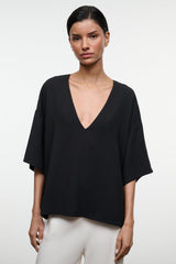Black studio tee with deep V-neckline and short sleeves, relaxed drape