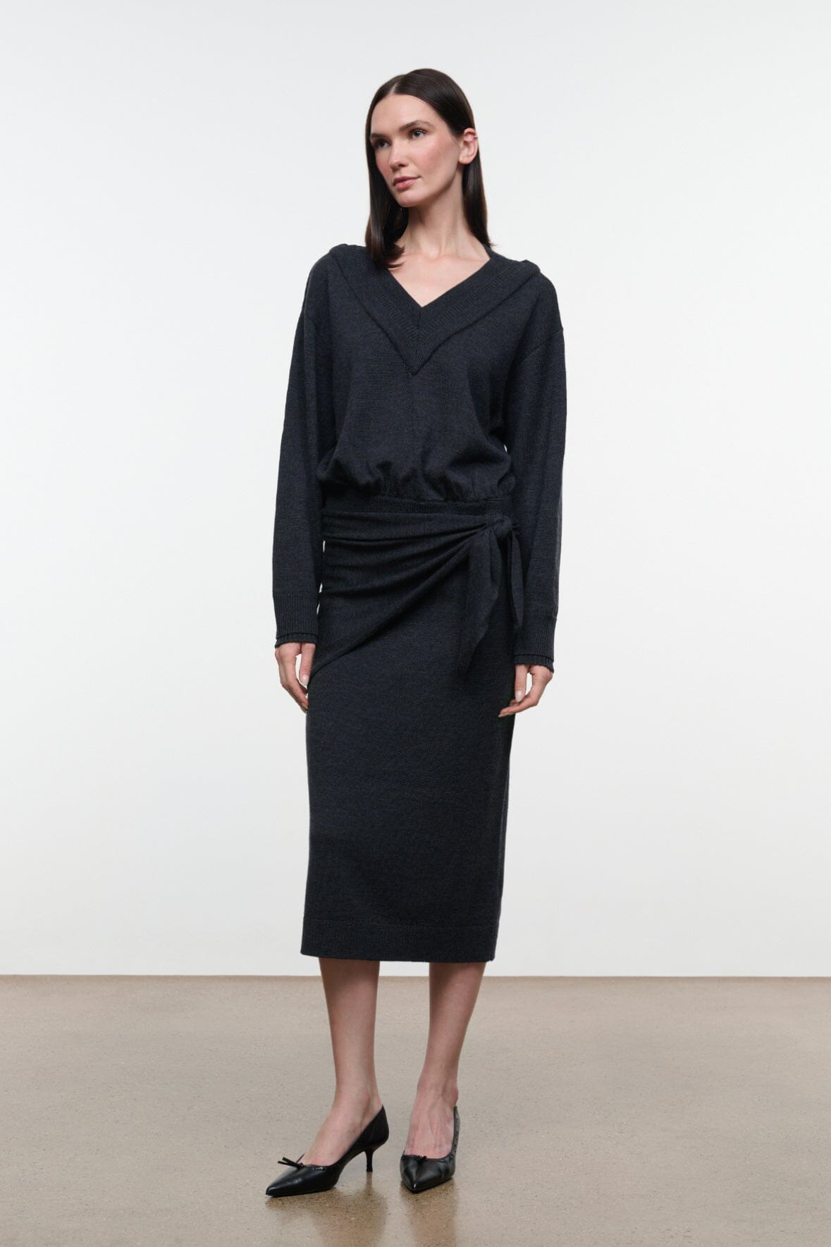 Charcoal V-neck sweater dress with long sleeves and knotted waist detail, midi