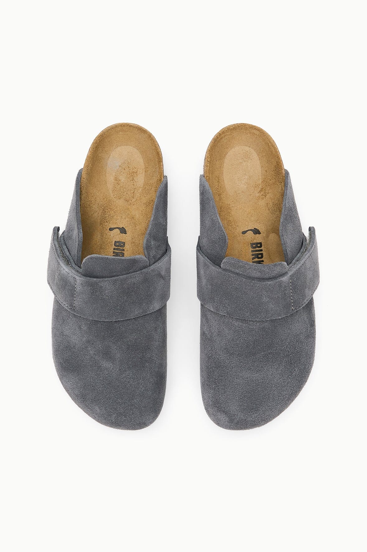 A pair of gray suede clogs with a wide strap across the instep, shown from a top-down view on a white background. The tan insoles display the brand name 'BIRCH'.