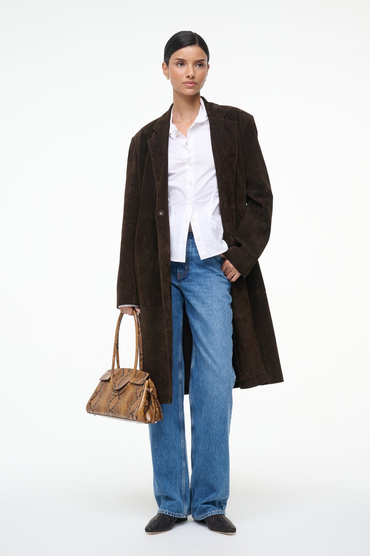 White button-up top with pointed collar peeking under dark coat