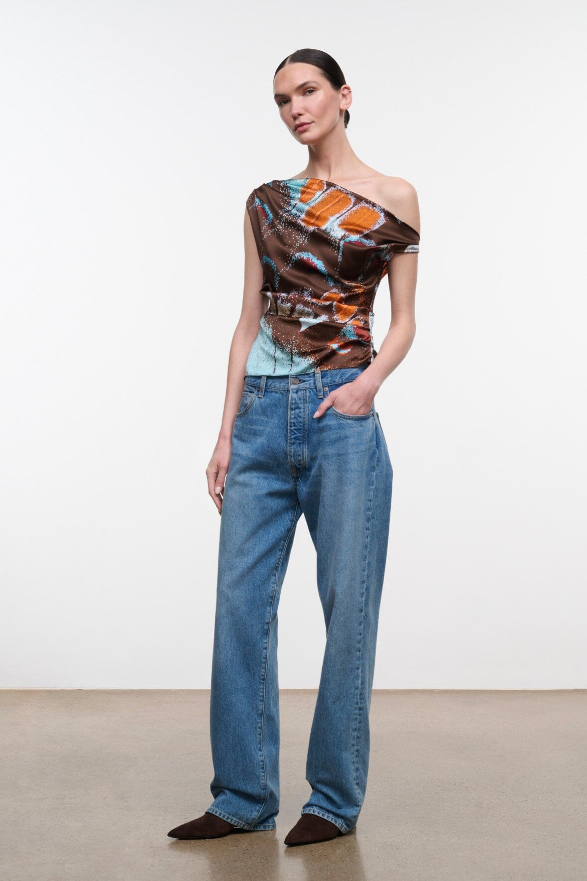 Silk one-shoulder top with draped neckline, brown orange turquoise butterfly print on model