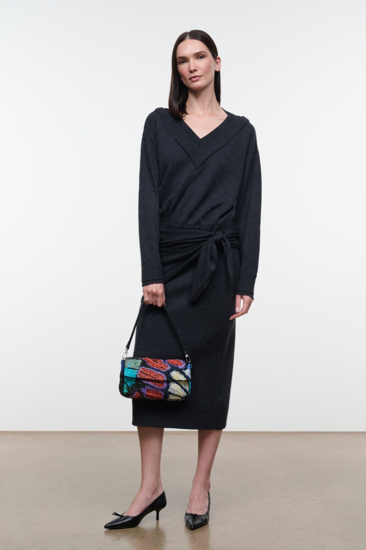 Charcoal V-neck sweater dress with long sleeves and tied waist, midi length