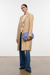 Women's tan leather coat with button front, side seam detail, and long hem