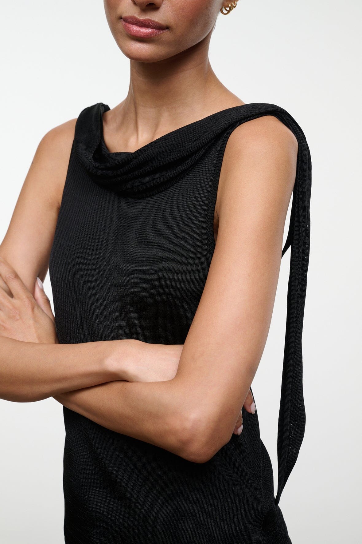 Black sleeveless top with cowl neck and draped one-shoulder tie