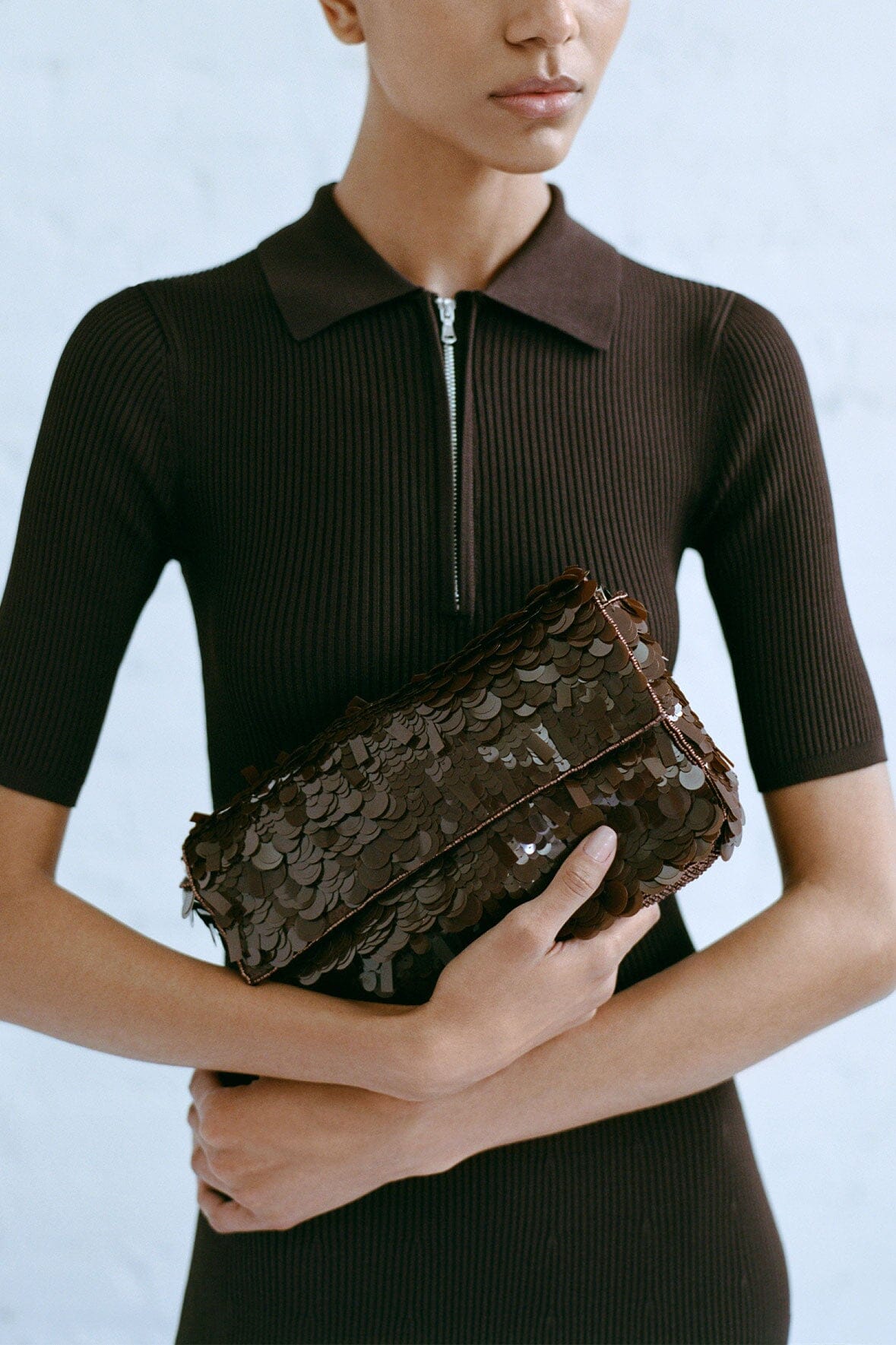 Cacao sequin shoulder bag worn by a model, showing front zipper details