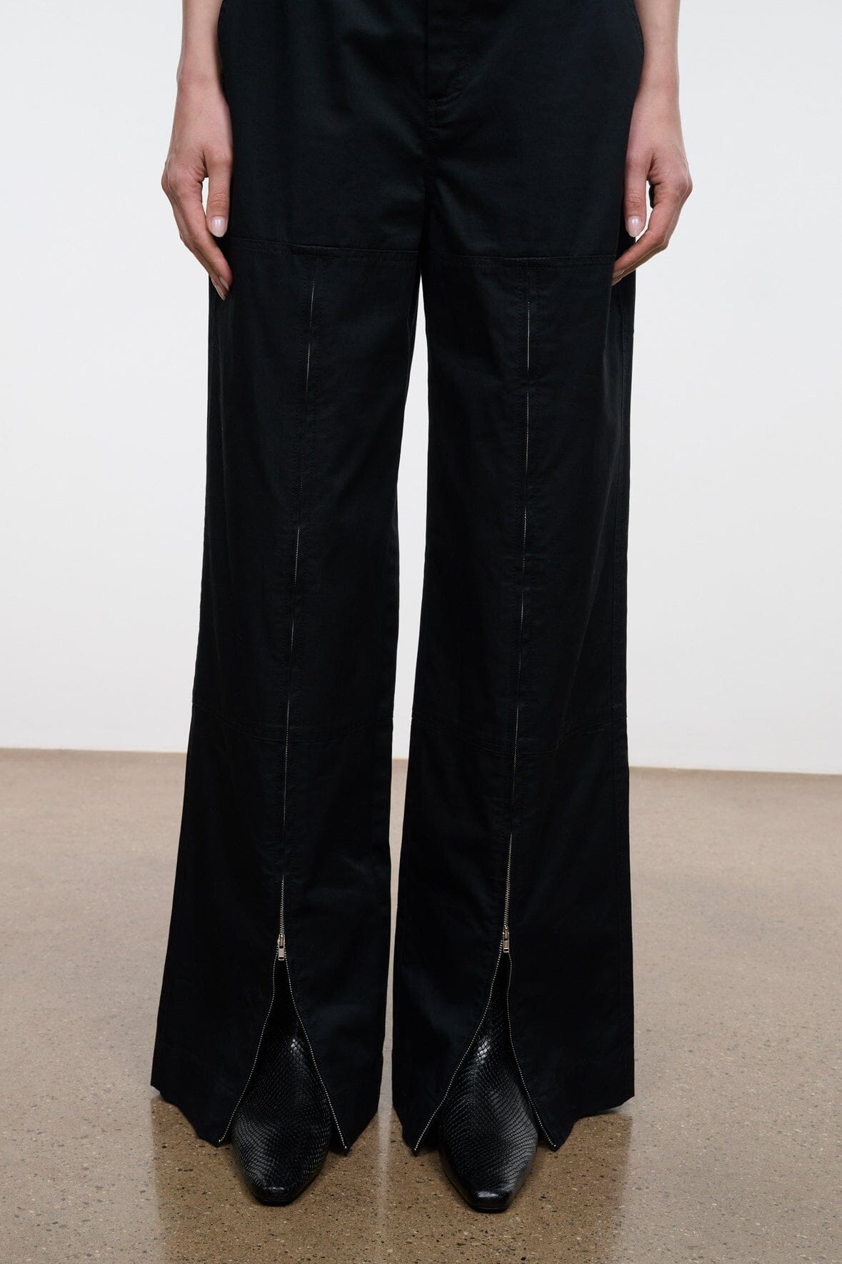 Black snake-texture flat ankle boots with pointed toe and low heel, front view.