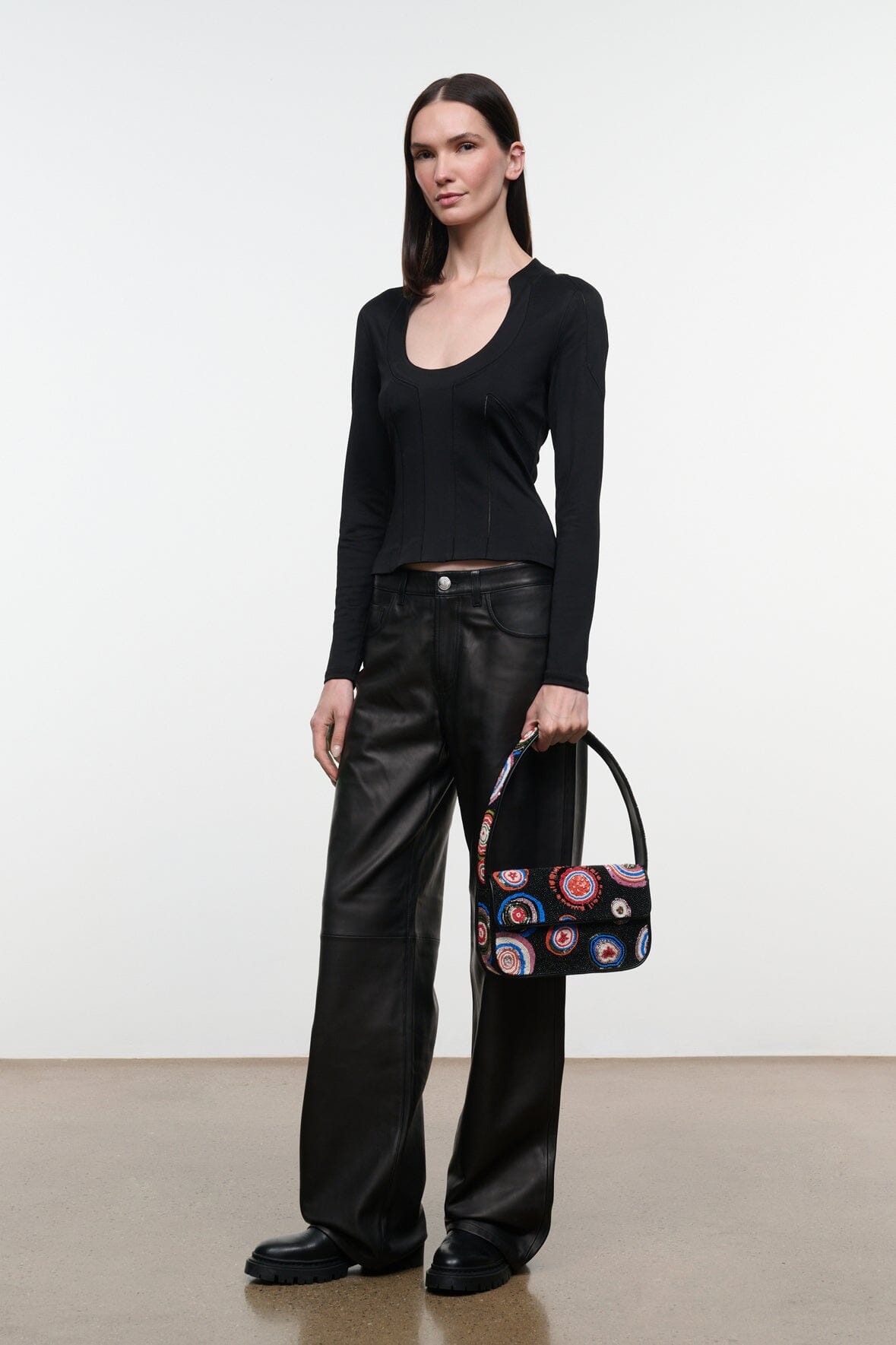 Black beaded handbag with colorful circular embroidery and top handle, flap closure