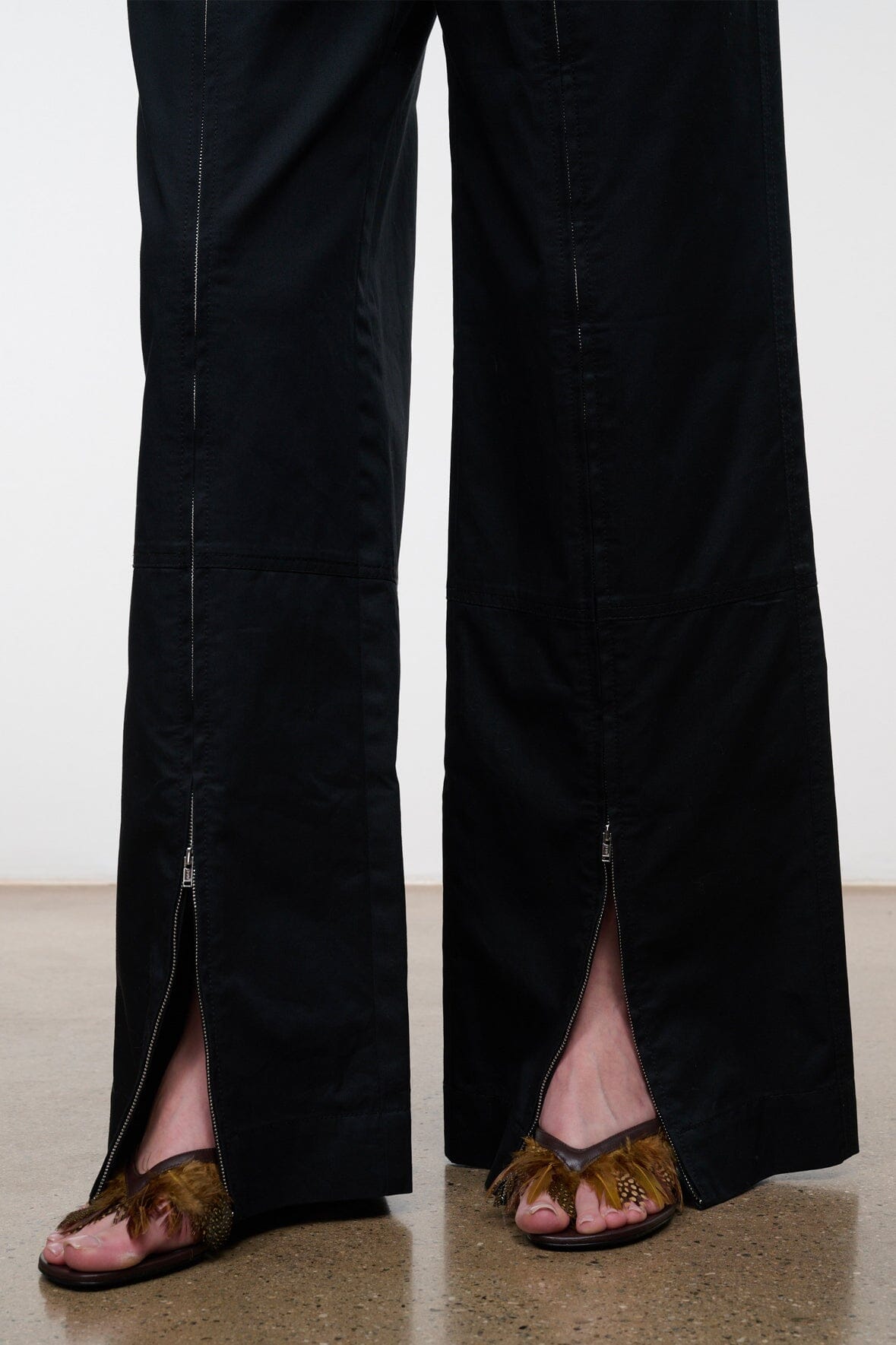 Black wide-leg pants with side slit and zippered ankle openings