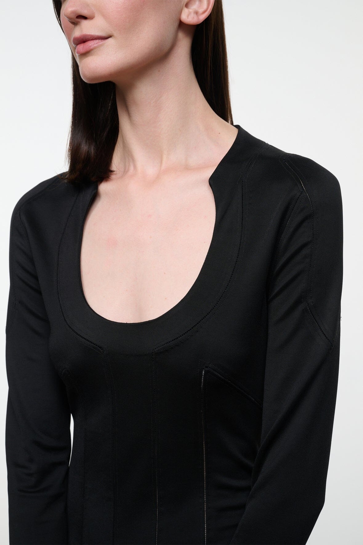 Black long-sleeve scoop-neck top with curved hem and fitted seams