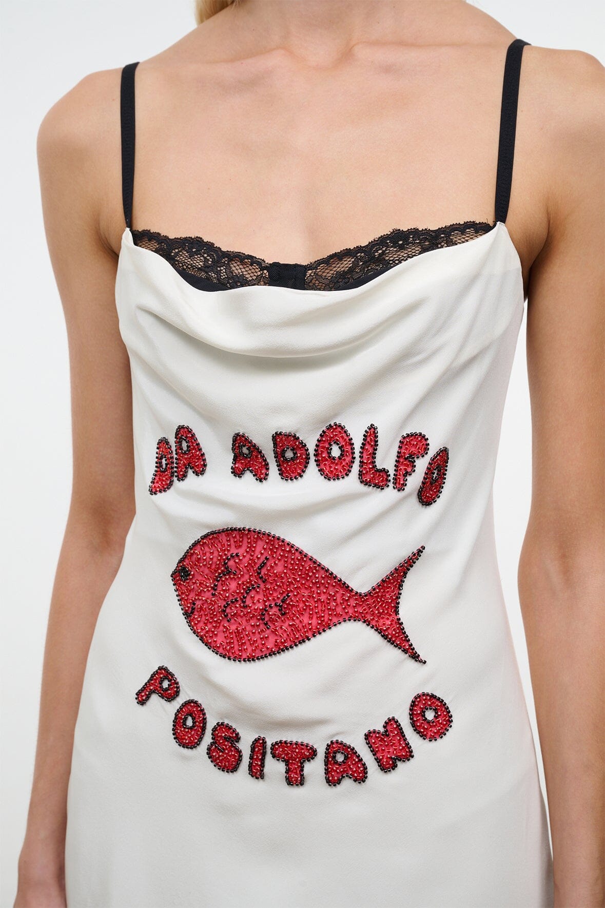 White silk mini dress bodice with black lace trim and red fish and Positano lettering