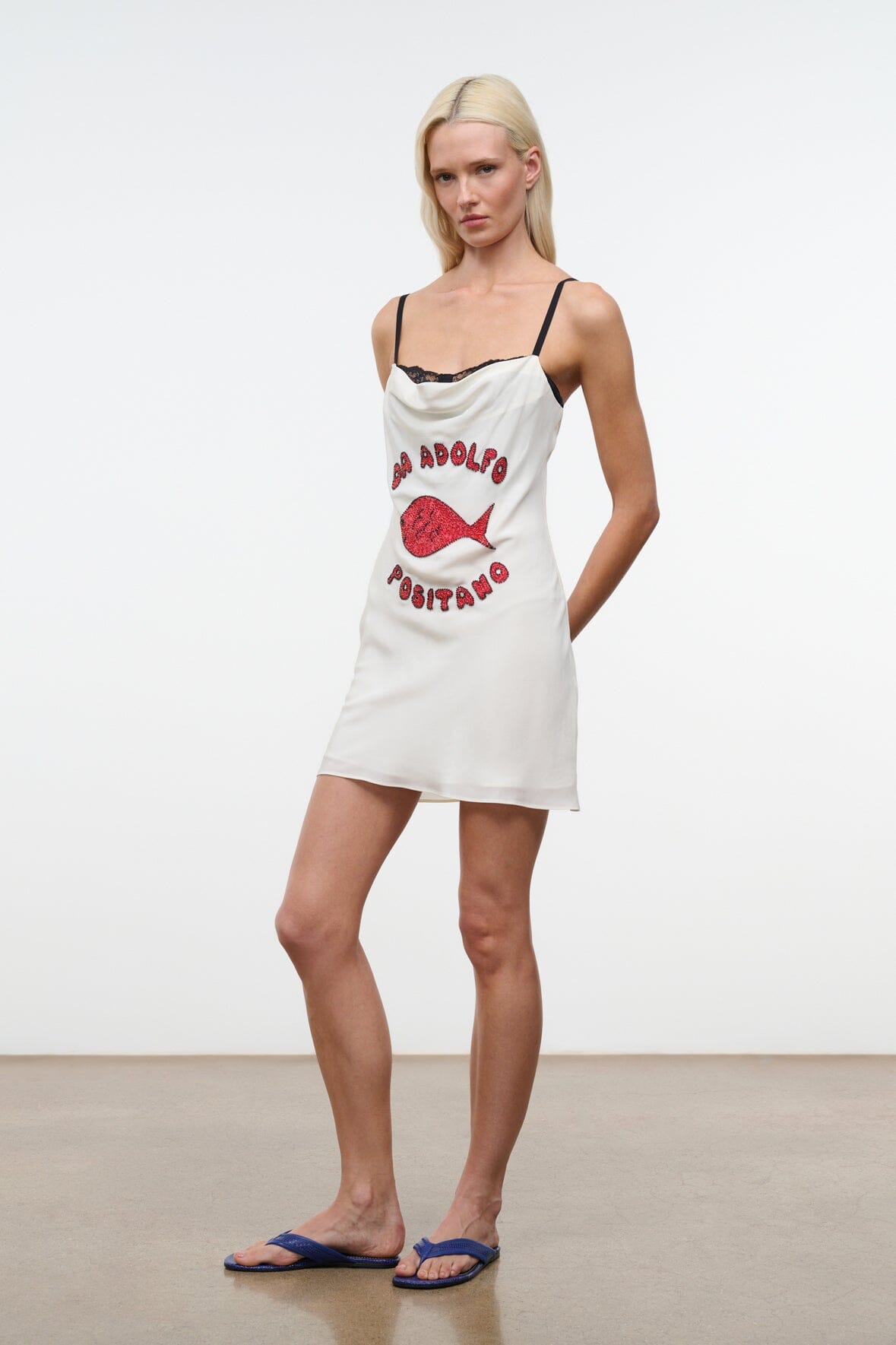 White mini dress with black lace neckline, red fish graphic, and Positano lettering