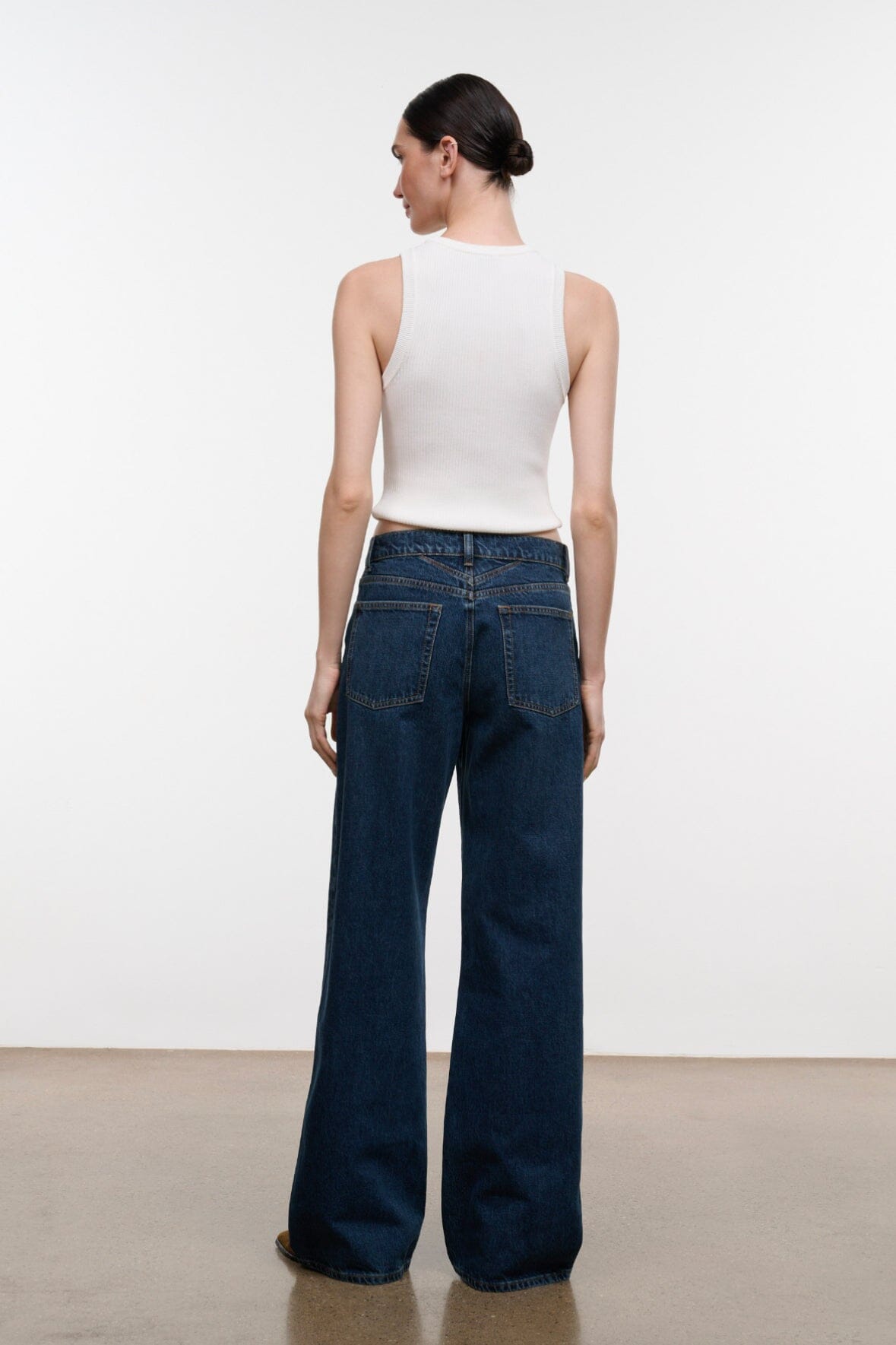 Relaxed dark-wash wide-leg jeans, rear view with patch pockets and belt loops