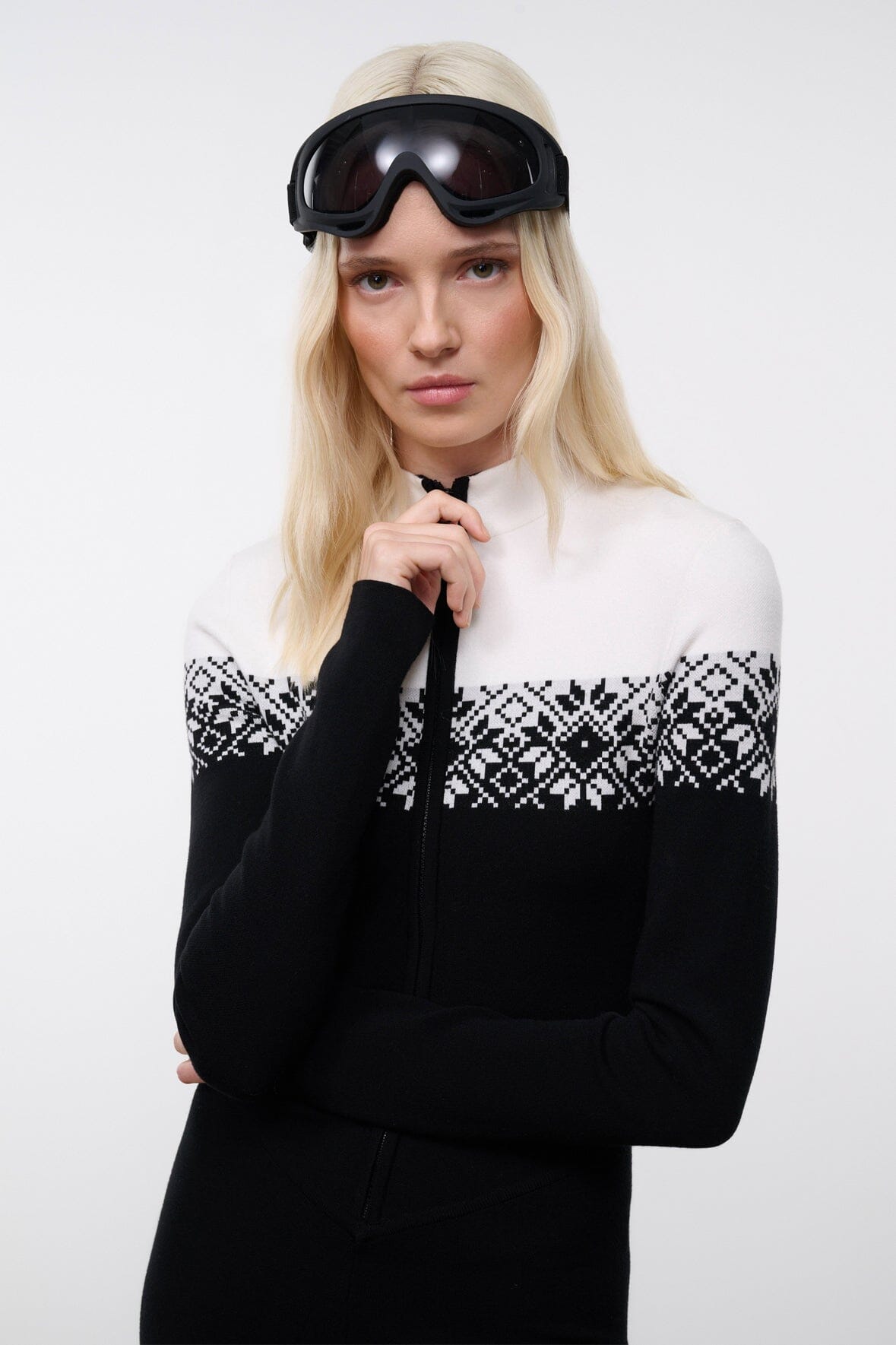 Black snowboard onesie with white fair isle yoke and zip-front; wearing ski goggles