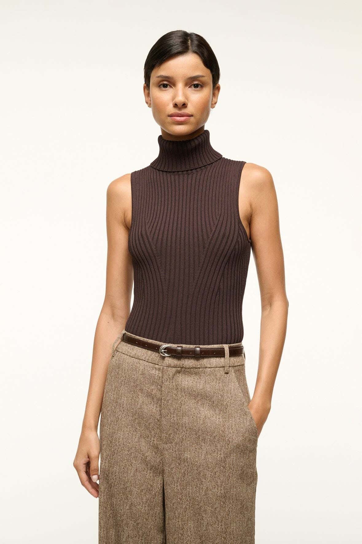 Slim brown leather belt with silver buckle worn at the waist