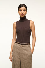 Slim brown leather belt with silver buckle worn at the waist