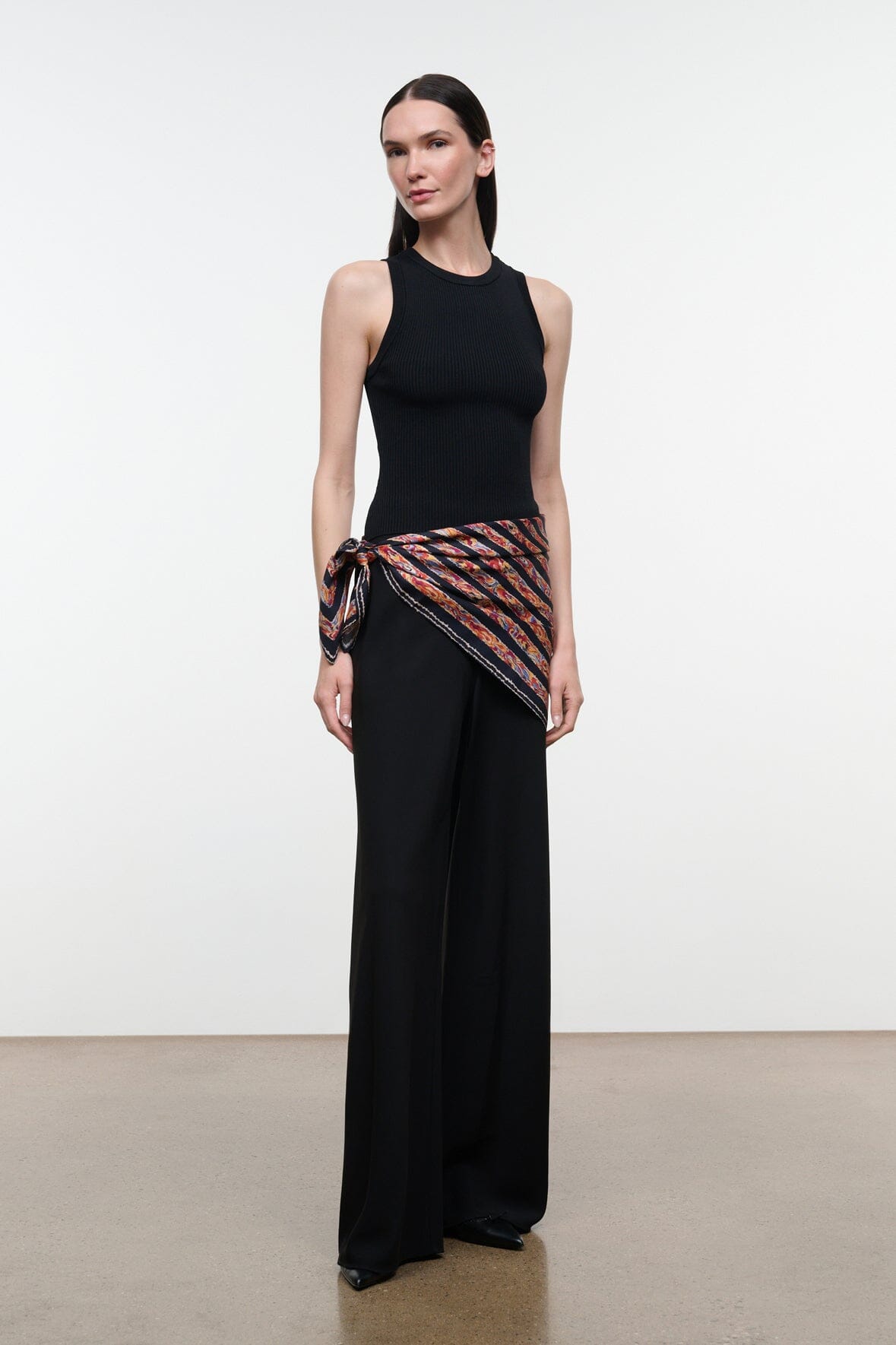 Silk scarf with multicolor geometric stripe pattern wrapped at waist with black dress