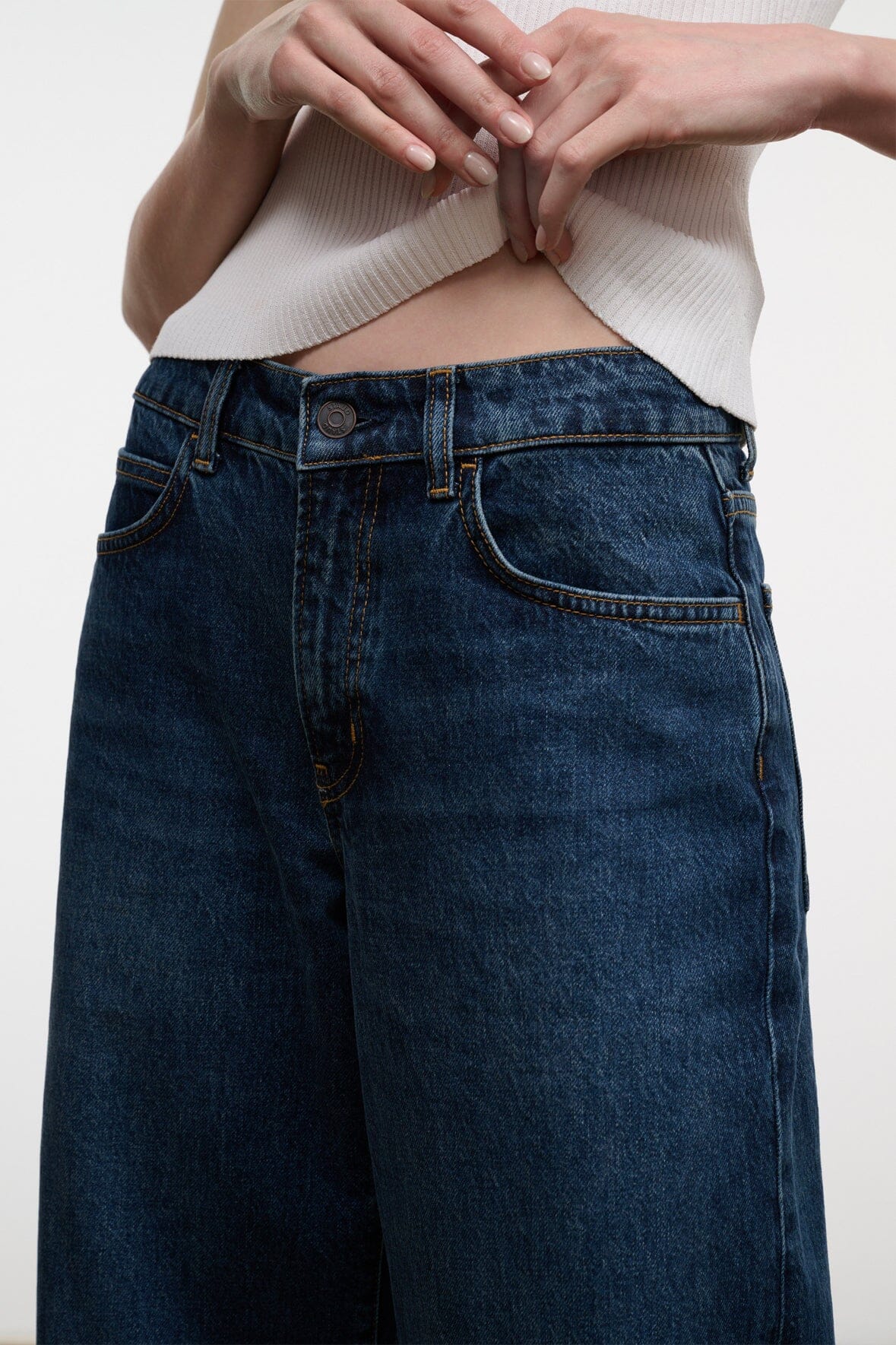 Dark-wash denim jeans with button-and-zip fly, belt loops, and front yoke