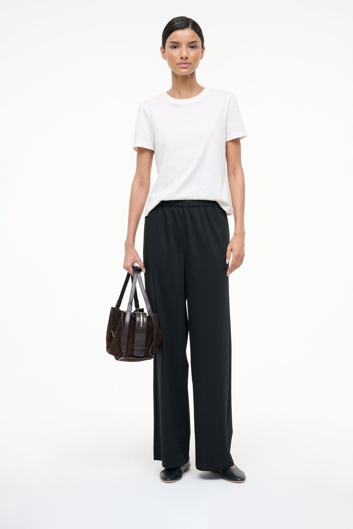 Black ballet flats worn with black pants and short-sleeve top