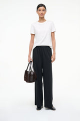 Black ballet flats worn with black pants and short-sleeve top