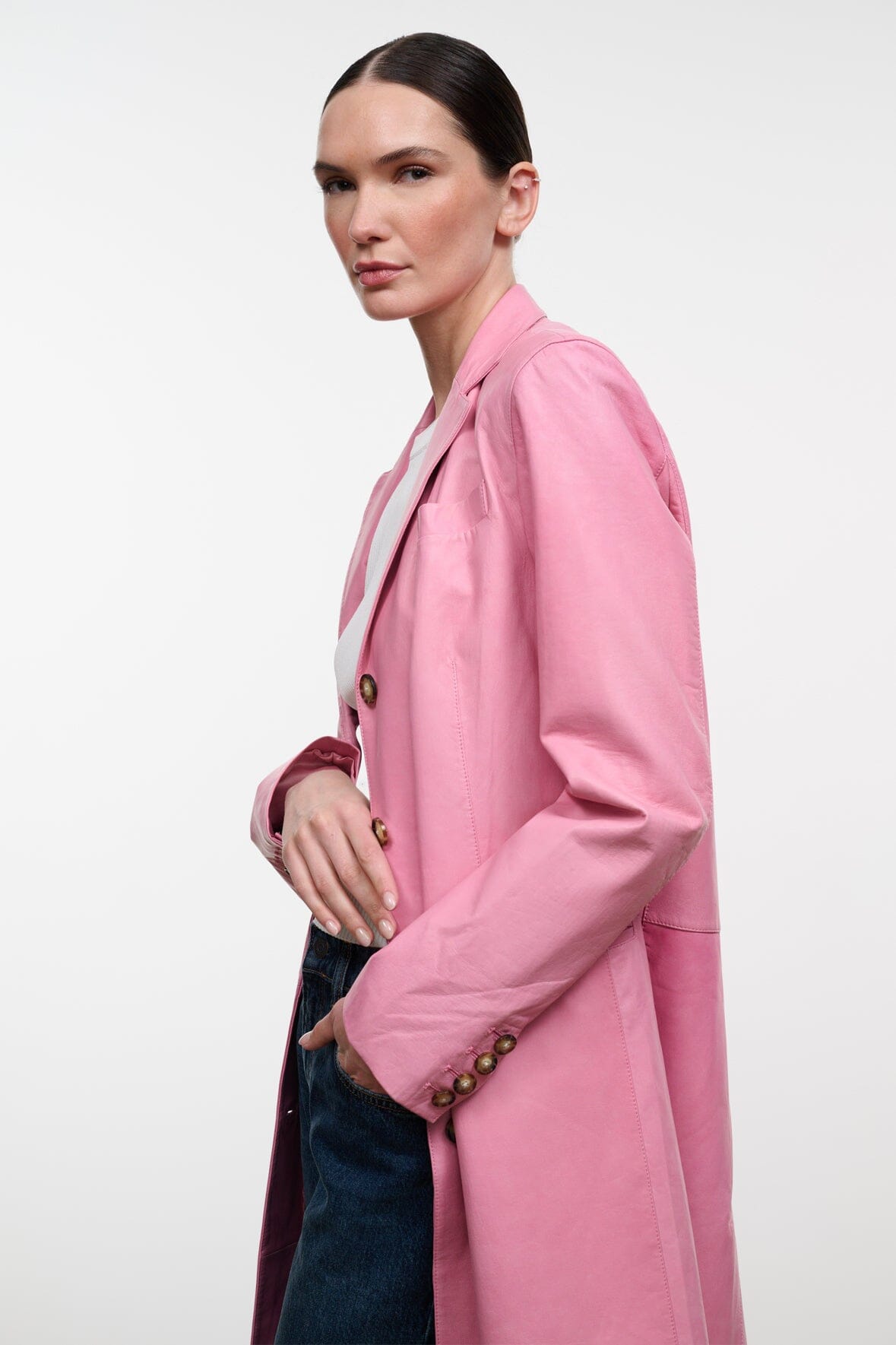 Pink leather coat close-up of shoulder and sleeve with gold-tone button details