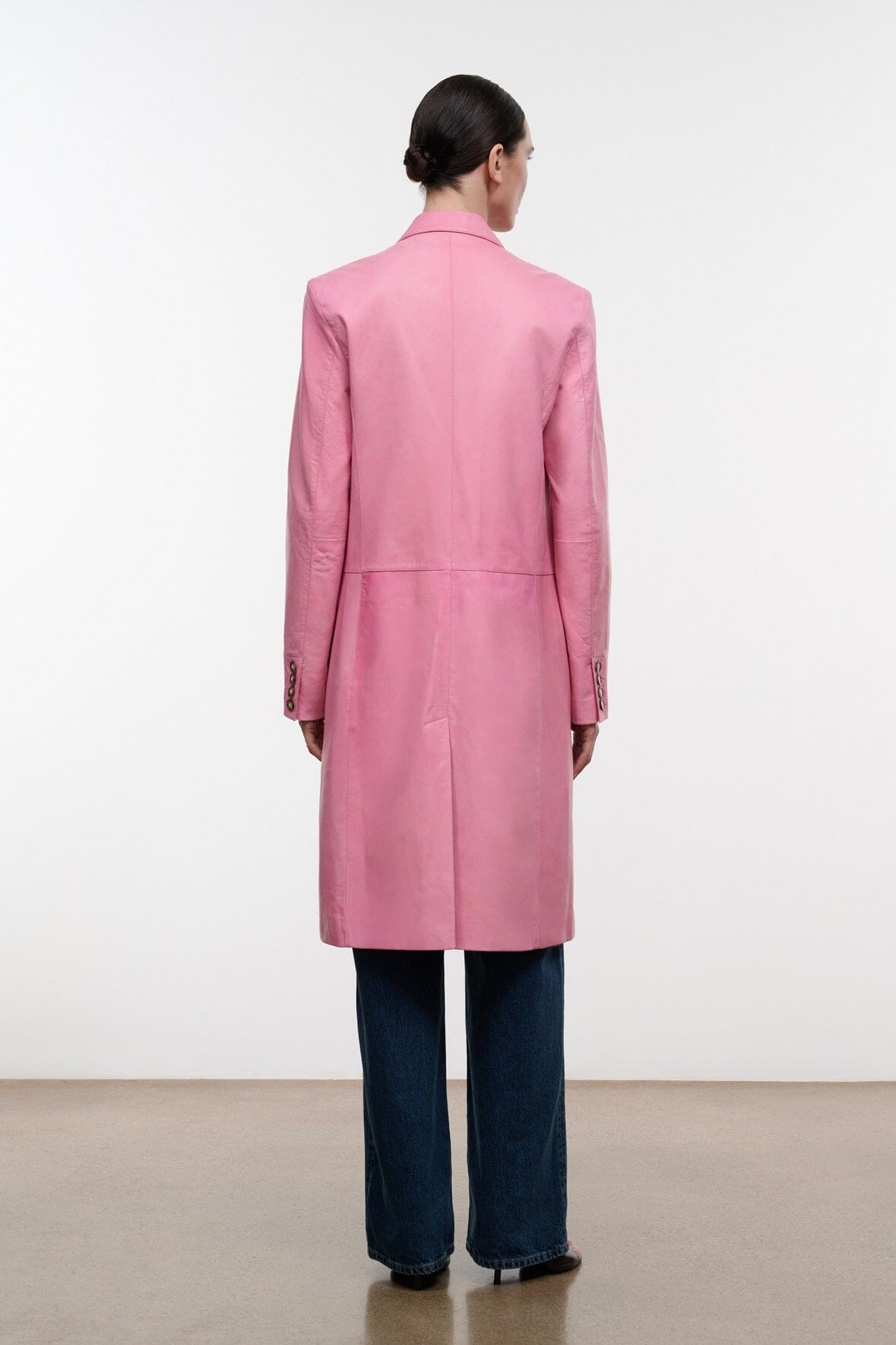Pink leather coat, back view, centered button placket and belt at waist