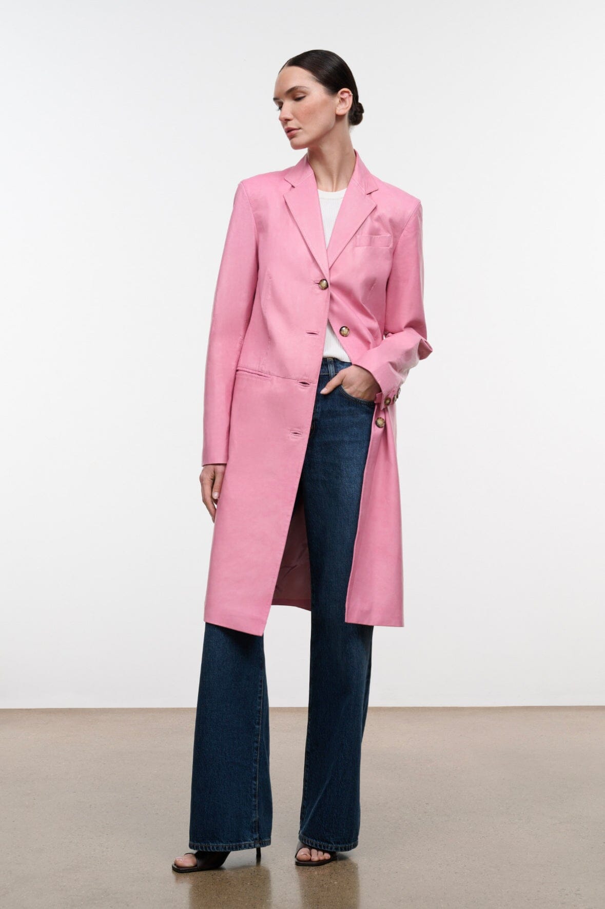Pink leather coat with notch lapels and gold-tone buttons, hip-length hem